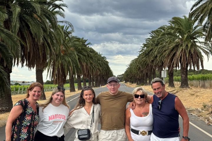 a group of people standing next to a palm tree